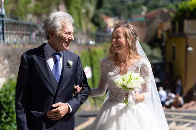 La sposa e chi l’accompagna ridono, a braccetto